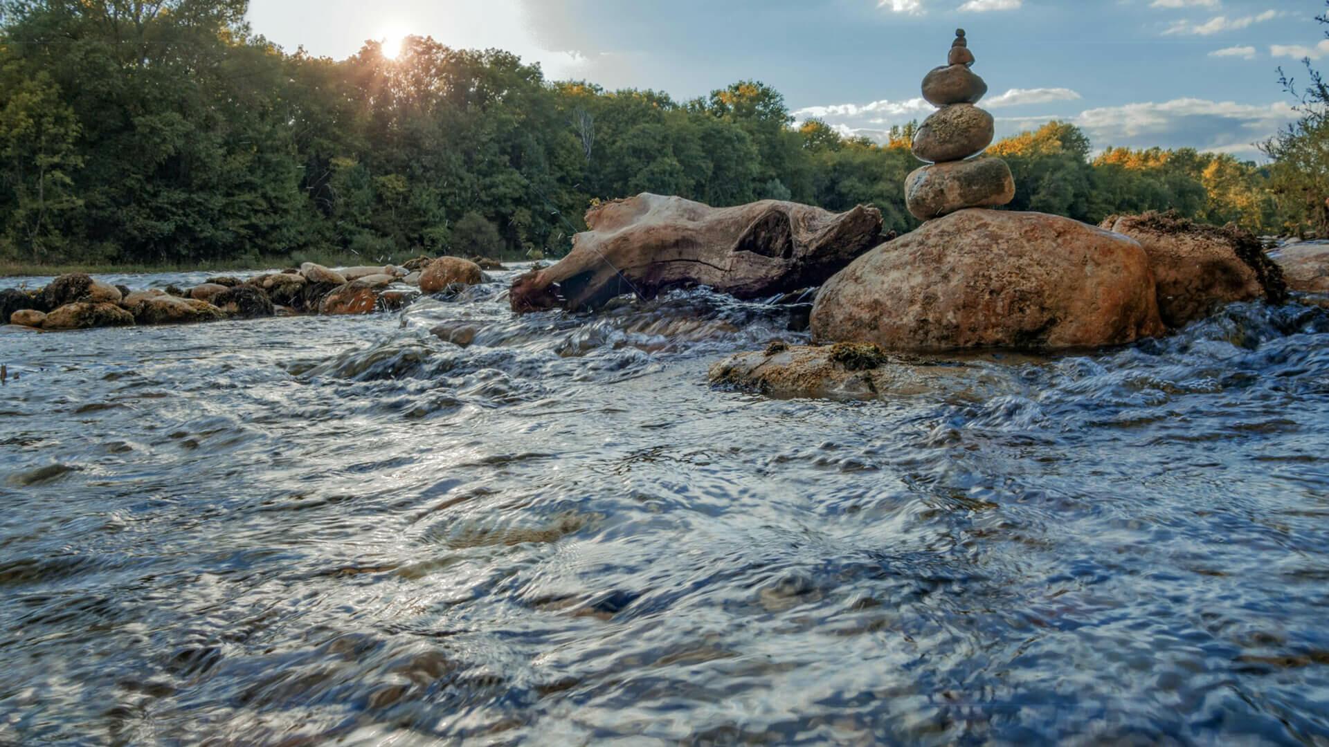 Cours d'eau dans l'Ain avec des cailloux entassés